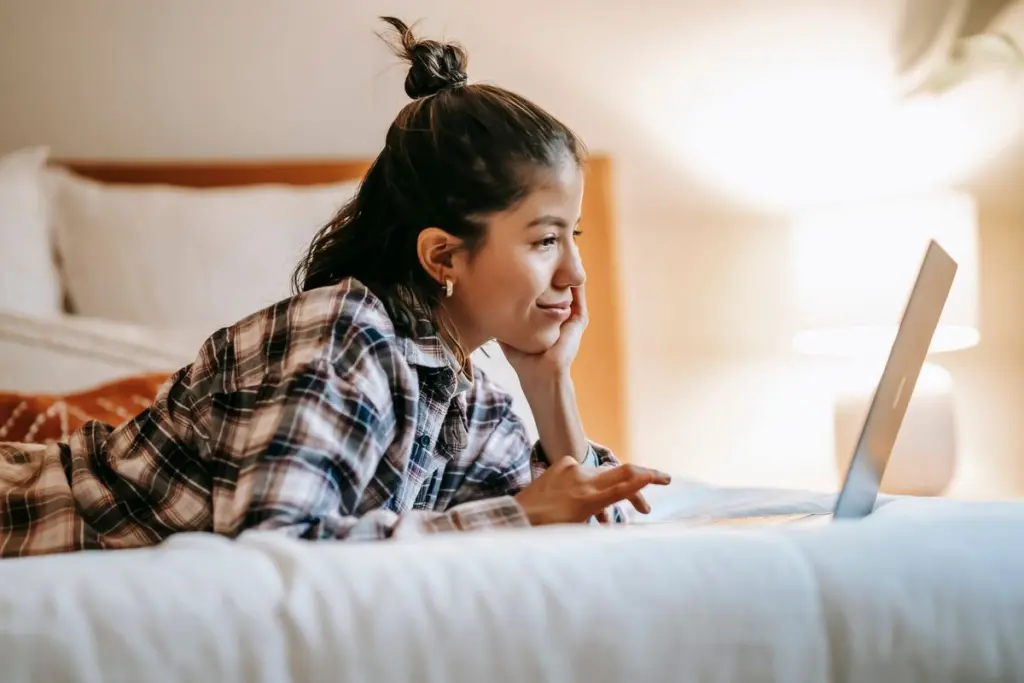 Persona comparando opciones de prestamo en linea desde casa con su laptop