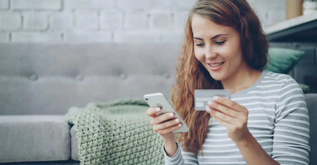 Mujer joven usando su telefono para un tramite en linea