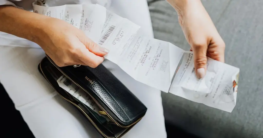 Persona pagando una factura con recibo en mano