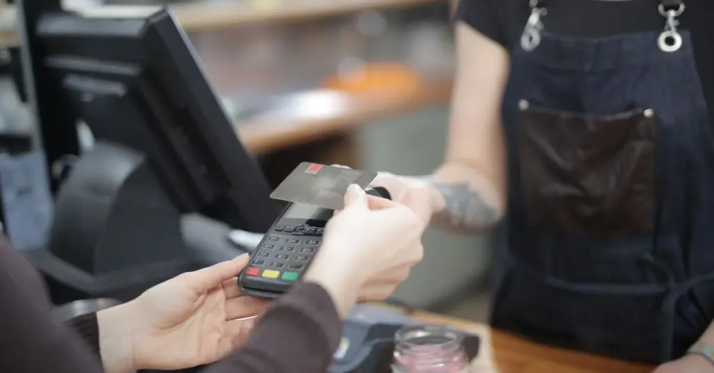 Cliente pagando con tarjeta de crédito en tienda
