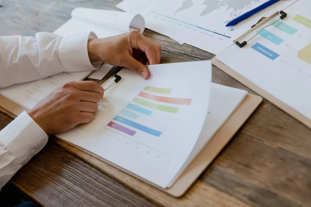 Manos revisando un reporte financiero con gráficos