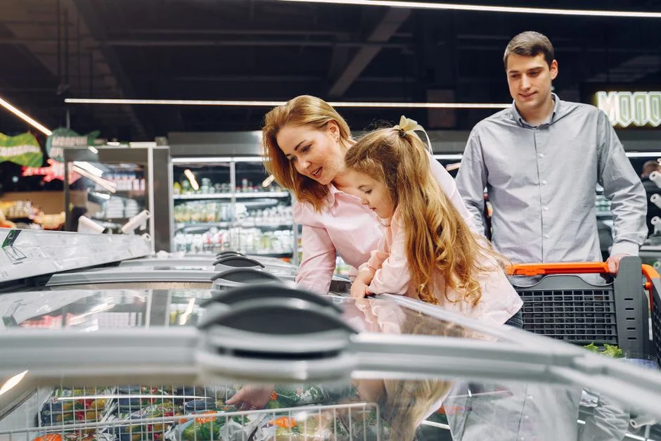 Familia haciendo compras de despensa juntos en el supermercado