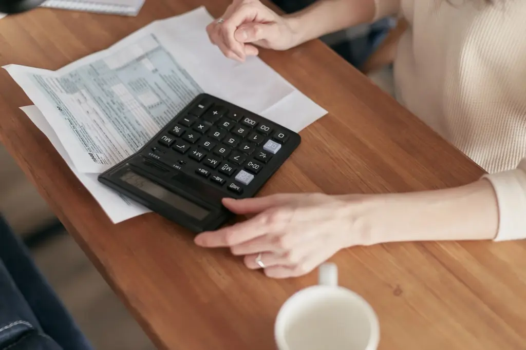 Persona usando calculadora para revisar sus finanzas personales
