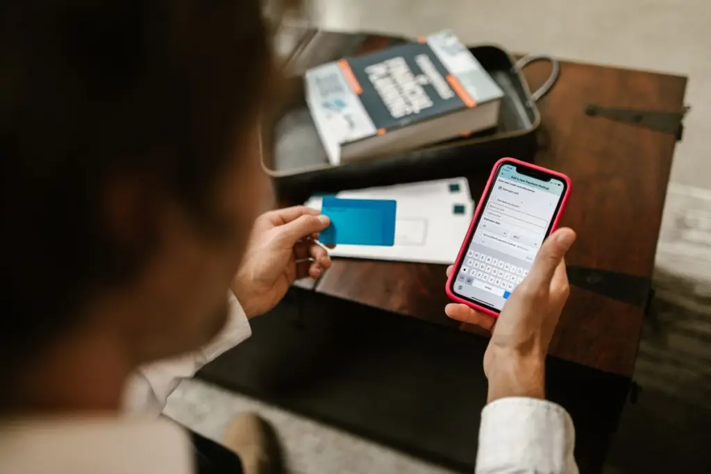 Persona revisando en su celular los pagos recibidos de clientes en una app bancaria