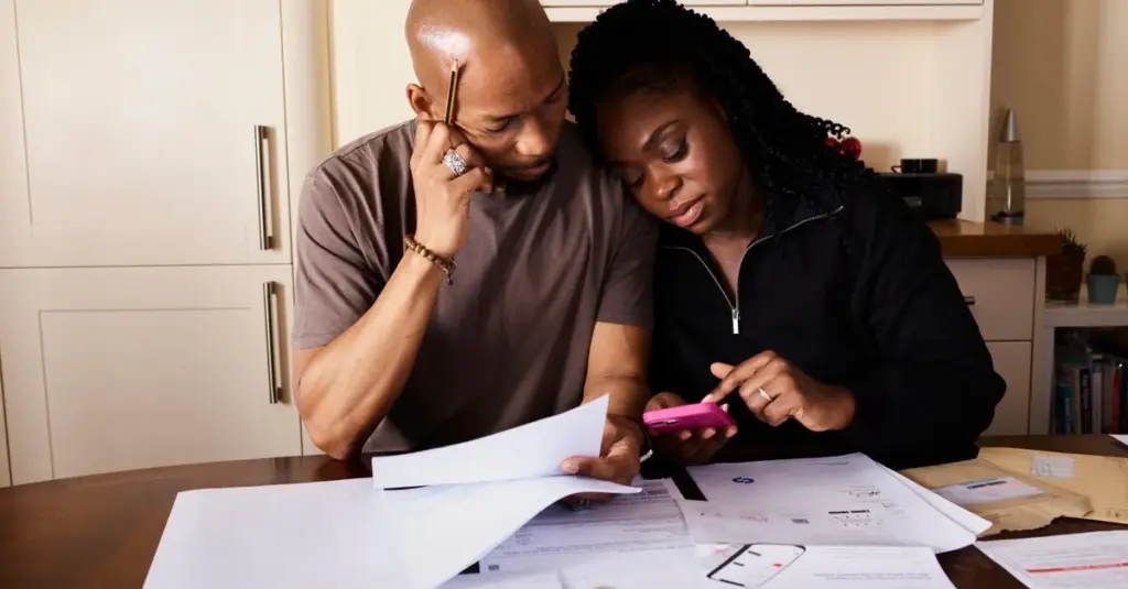Pareja revisando gastos y finanzas en una mesa