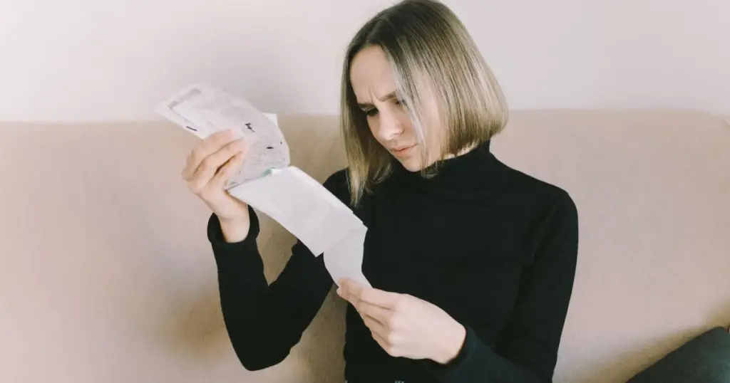 Mujer preocupada revisando recibos y documentos
