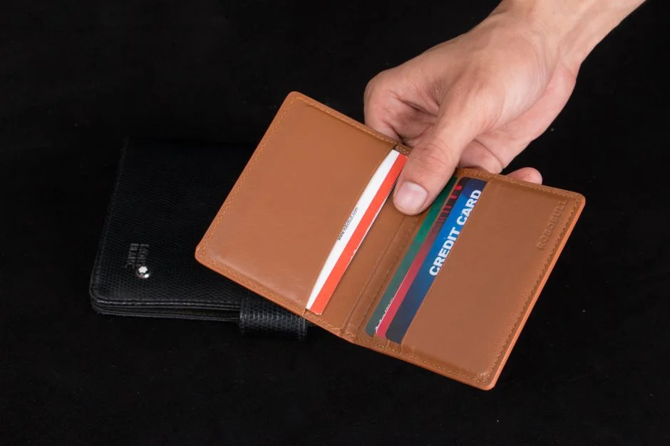 Mano sosteniendo una cartera abierta con varias tarjetas de crédito
