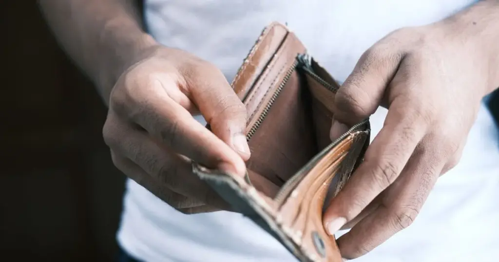 Persona revisando una cartera vacía