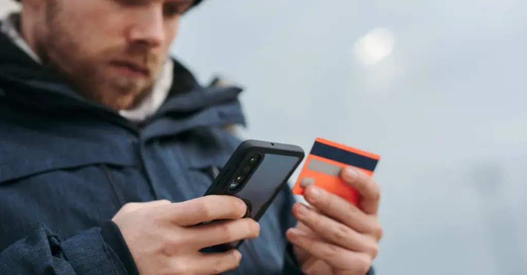 Hombre pagando con tarjeta de credito desde el celular