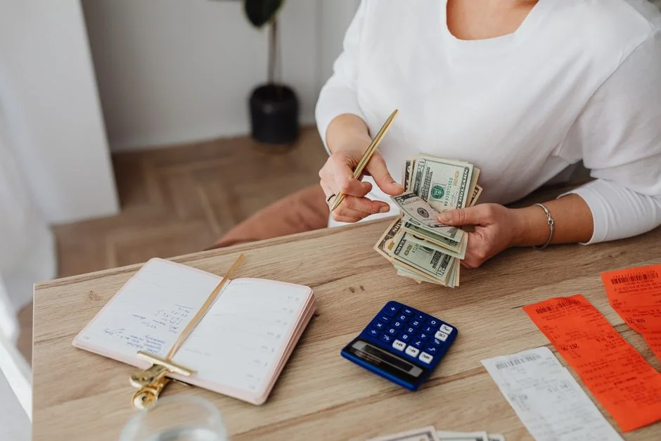Mujer contando dinero y organizando su presupuesto en un escritorio
