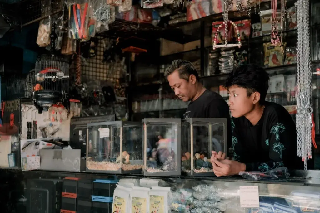 Padre e hijo atendiendo juntos un pequeño negocio familiar