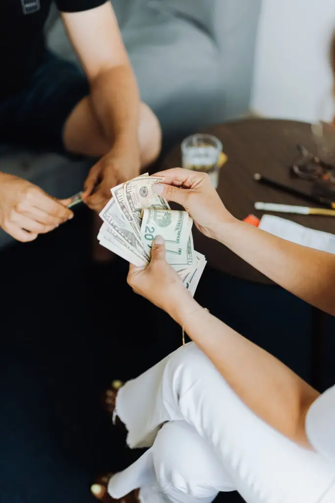 Manos contando billetes de pesos mexicanos en un pequeño negocio
