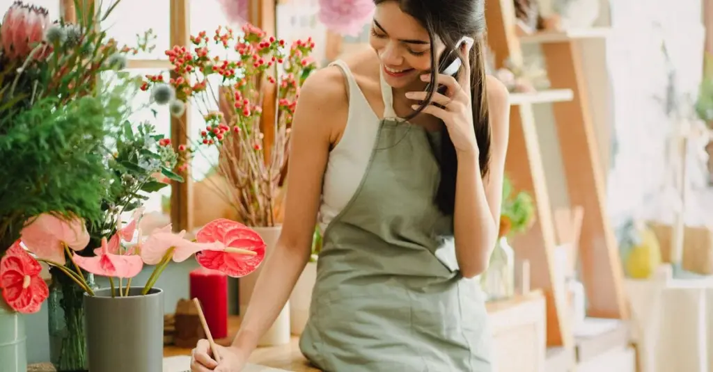 Trabajadora independiente en su pequeño negocio revisando su celular