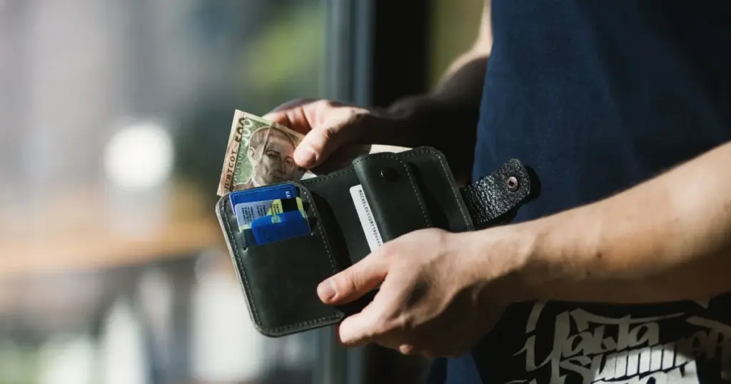 Persona sacando dinero en efectivo de su billetera