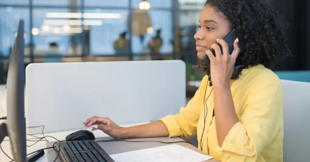 Persona en oficina hablando por teléfono para reclamar un cobro