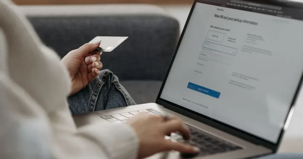 Mujer comprando online con tarjeta de crédito en su laptop