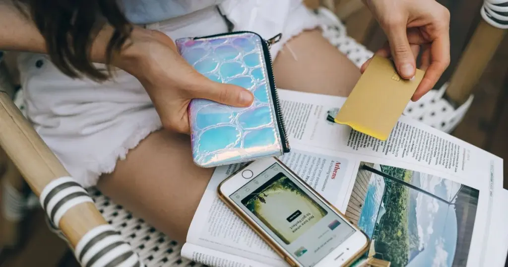 Joven revisando su billetera y tarjetas
