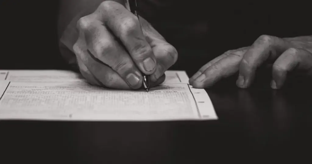 Persona firmando o llenando un formulario de solicitud de crédito