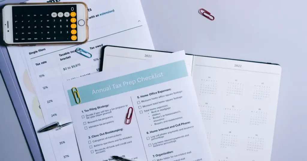 Checklist financiero con calculadora y calendario sobre un escritorio