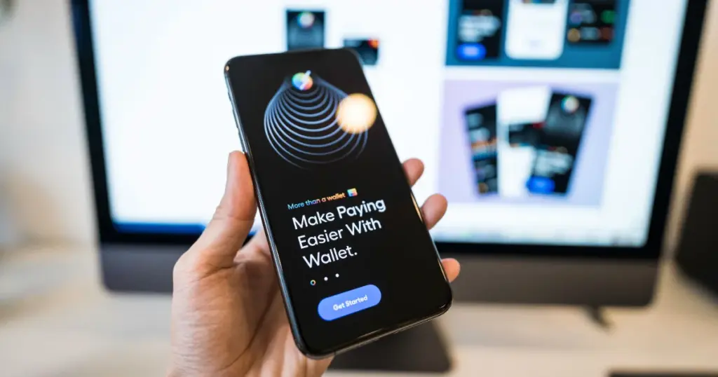 Mano sosteniendo un celular con una app de billetera digital abierta