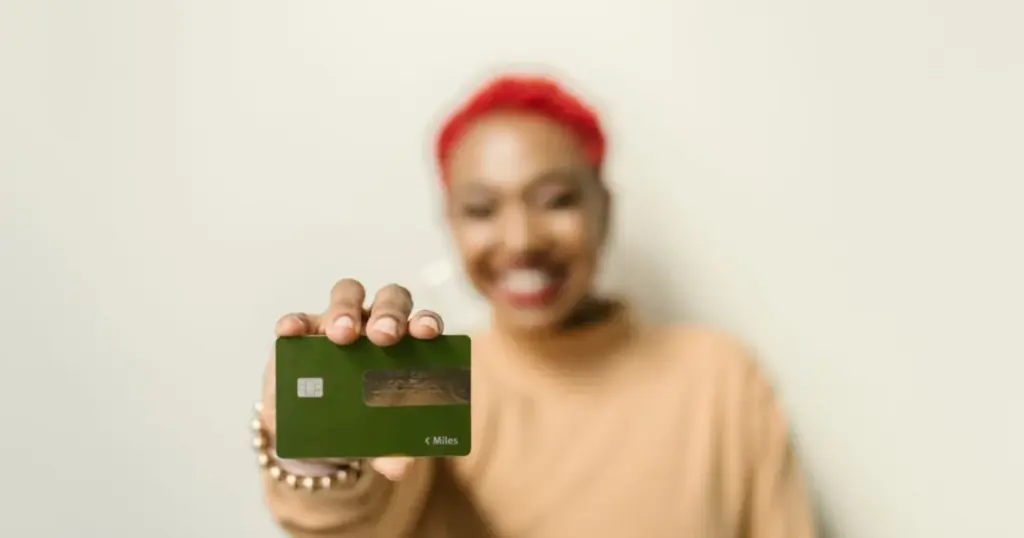 Mujer sonriendo con su tarjeta de credito
