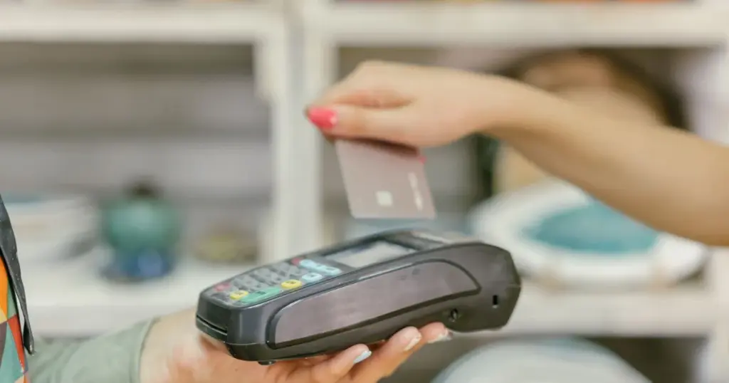 Persona pagando con tarjeta de crédito en un terminal de pago
