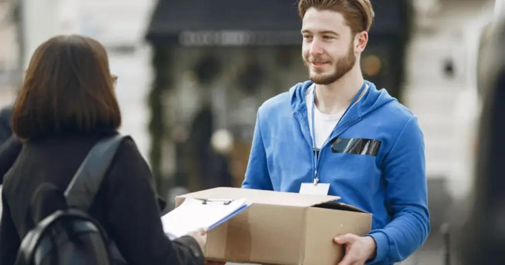 Repartidor de delivery entregando un paquete a una clienta en la calle