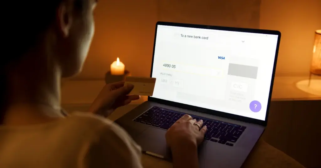 Mujer haciendo un pago online seguro con laptop y tarjeta de crédito
