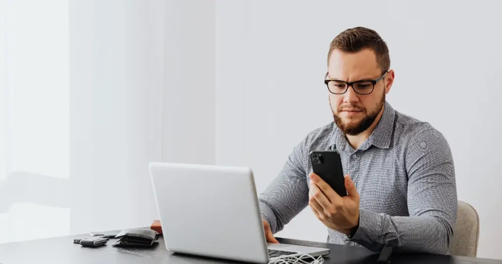Trabajador independiente revisando sus ingresos en laptop y celular