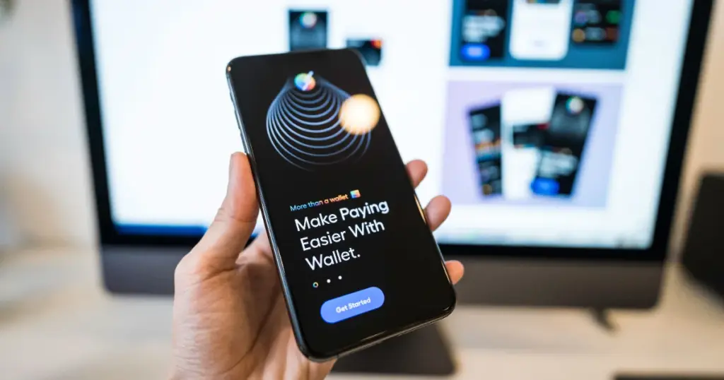 Mano sosteniendo un teléfono con una app de billetera digital