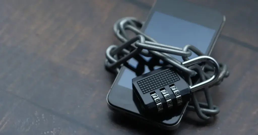 Celular envuelto en cadena con candado, simbolizando seguridad