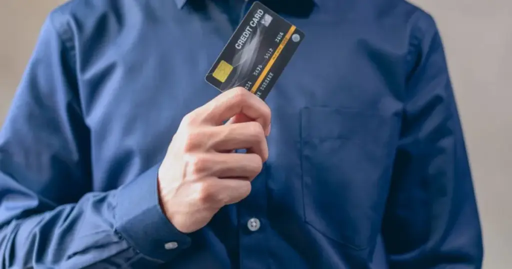 Hombre sosteniendo una tarjeta de crédito