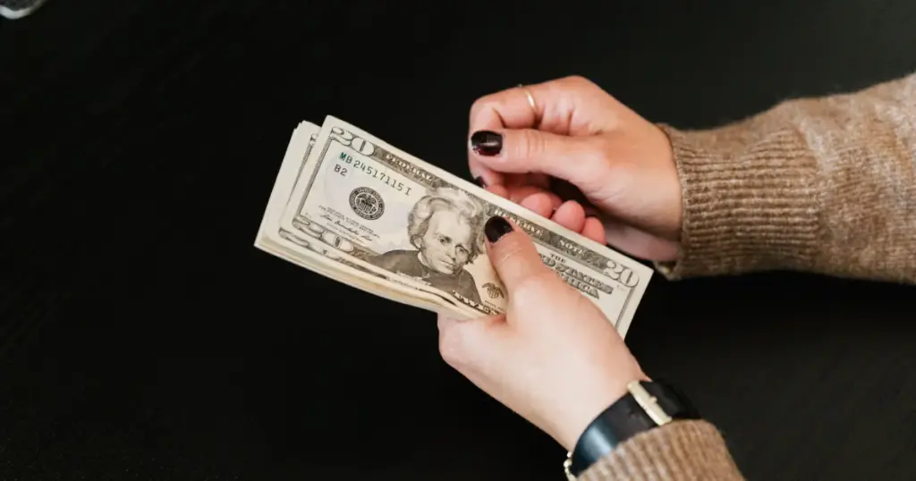 Persona contando billetes de dólares en efectivo