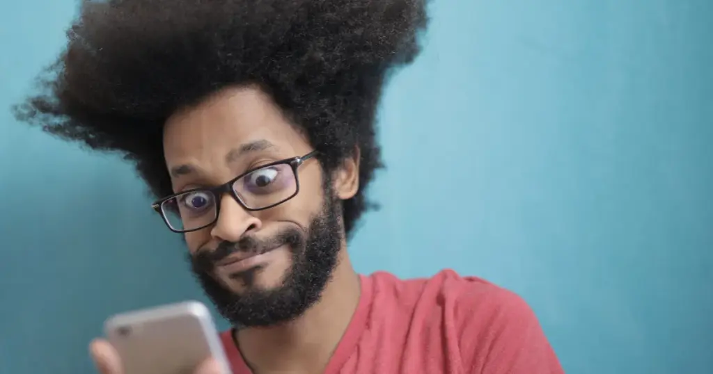 Hombre sorprendido mirando la pantalla del celular