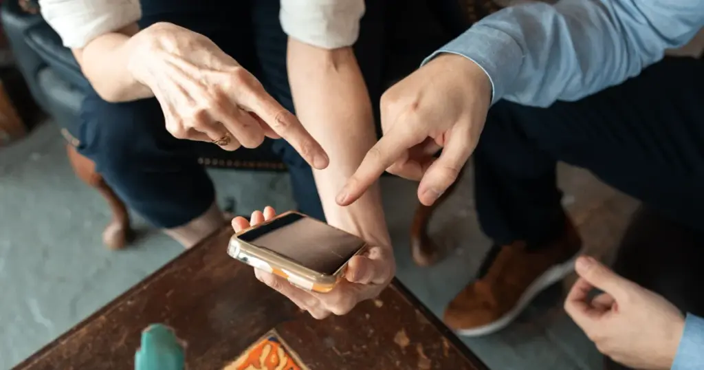 Dos personas revisando un comprobante de pago en el celular