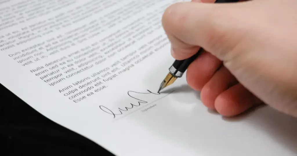 Persona firmando documento de negocio