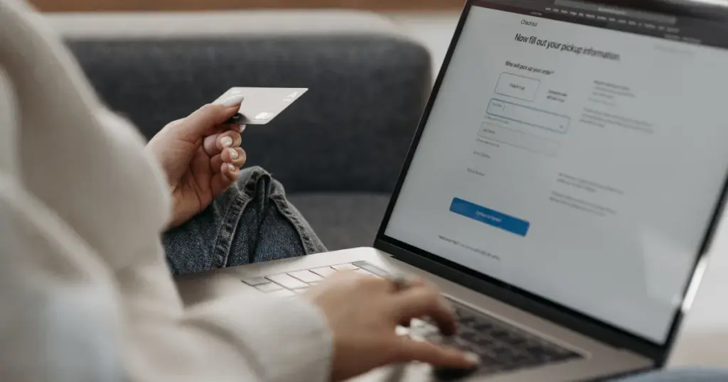 Persona con tarjeta haciendo compras en línea desde el sofá