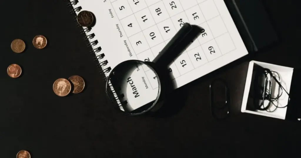 Calendario y lupa para planificar finanzas