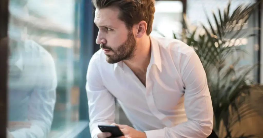 Hombre preocupado revisando el celular