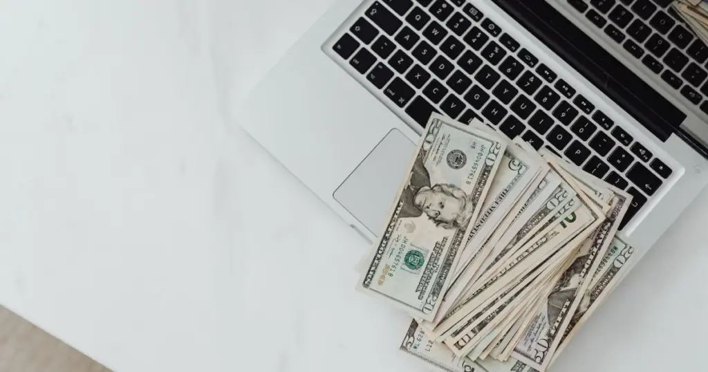 Billetes de dólares sobre laptop, planificación financiera