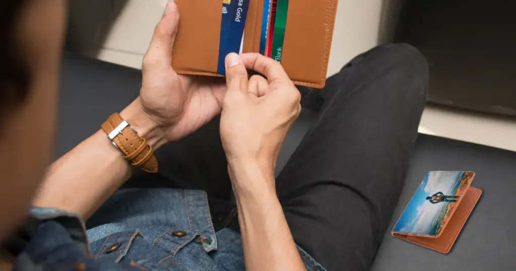 Primer plano de una persona sosteniendo una billetera con varias tarjetas de crédito