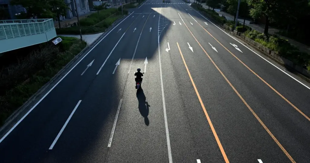 Motorizado conduciendo por la calle de la ciudad