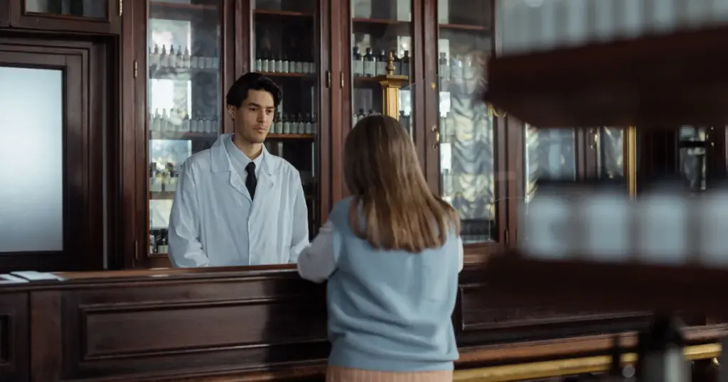 Farmacéutico atendiendo a un cliente en el mostrador de una farmacia
