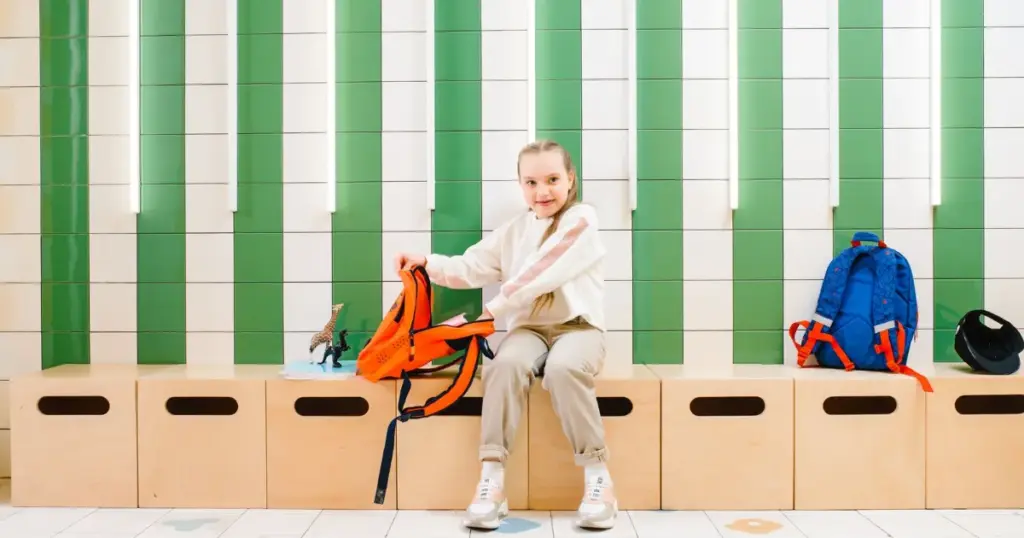 Niña con mochila escolar comprando útiles